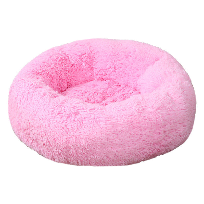 Pink donut-shaped pet bed on a white background
